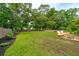 Expansive backyard featuring a grassy lawn, trees, and patio seating area at 1928 Gasque St, Johns Island, SC 29455