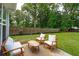 Patio featuring outdoor seating in a backyard framed by lush greenery and a wooden fence at 1928 Gasque St, Johns Island, SC 29455