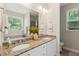 Bathroom featuring double sinks, granite countertops, vanity mirror, and a garden tub at 1928 Gasque St, Johns Island, SC 29455