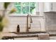 Close-up of kitchen sink with stainless faucet, granite counters, and white tile backsplash at 1928 Gasque St, Johns Island, SC 29455