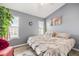 Cozy bedroom with light-colored bedding, multiple windows, and red upholstered chair at 201 Pine Shadow Dr, Goose Creek, SC 29445