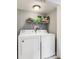 Convenient laundry room with white washer and dryer, plus storage shelving at 201 Pine Shadow Dr, Goose Creek, SC 29445