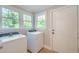 Well-lit laundry room features a side-by-side washer and dryer with views to the exterior at 208 State St, Walterboro, SC 29488