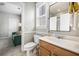 Well-lit bathroom featuring a wood vanity and fixtures, with a view into the adjacent living area at 209 Barberry St, Summerville, SC 29483