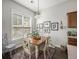 Cozy dining area with a wooden table, four chairs, rug, pendant light, and a large window with bright natural light at 209 Barberry St, Summerville, SC 29483