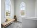 Bright hallway featuring arched windows, neutral walls and carpet, and a charming bench at 209 Barberry St, Summerville, SC 29483