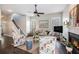 Inviting living room featuring a fireplace, neutral sofa, and floral armchairs, illuminated by natural light and a ceiling fan at 209 Barberry St, Summerville, SC 29483