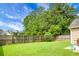 Private backyard features lush green grass, a wooden fence, and mature trees, creating a serene outdoor space at 213 Avonshire Dr, Summerville, SC 29483