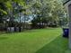 Large backyard featuring green grass and mature trees at 2174 Eleanor Dr, North Charleston, SC 29406