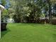 Well-maintained backyard with lush green grass, mature trees, and a shed for storage at 2174 Eleanor Dr, North Charleston, SC 29406