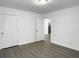 A bright bedroom with white walls, modern gray flooring, and multiple door entry points at 2174 Eleanor Dr, North Charleston, SC 29406