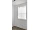 A minimalist bedroom with white walls, wood flooring, and a bright window with privacy blinds at 2174 Eleanor Dr, North Charleston, SC 29406