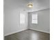 Cozy bedroom featuring two bright windows, white walls, and grey wood-look floors at 2174 Eleanor Dr, North Charleston, SC 29406