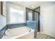 Modern bathroom with soaking tub, tiled shower, mosaic tile floor, and natural light at 224 Wappoo Trace Ln, Summerville, SC 29486