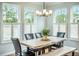Bright dining room featuring a wood table with black leather chairs, bench, and natural light from shuttered windows at 224 Wappoo Trace Ln, Summerville, SC 29486