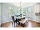 Bright dining room featuring a wood table with black leather chairs, bench, and natural light from shuttered windows at 224 Wappoo Trace Ln, Summerville, SC 29486