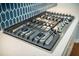 Close up of a stainless steel gas cooktop and blue backsplash at 224 Wappoo Trace Ln, Summerville, SC 29486