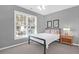 Cozy bedroom featuring a bed with white bedding, wood nightstand, ceiling fan, and large window view at 2257 Magnolia Meadows Dr, Mount Pleasant, SC 29464
