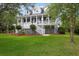 Elegant two-story home with charming porch, white railings and stairs, surrounded by a well-manicured green lawn at 2293 Beckenham Dr, Mount Pleasant, SC 29466