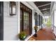 Charming front porch with wood flooring, comfortable seating, stylish lighting, and classic white columns at 2293 Beckenham Dr, Mount Pleasant, SC 29466