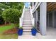 Exterior staircase ascends to the home's entrance, framed by vibrant blue planters and lush landscaping at 2293 Beckenham Dr, Mount Pleasant, SC 29466