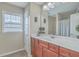 Bathroom showcasing a vanity with a large framed mirror, wood-look cabinetry, and a decorative window at 240 Mayfield Dr, Goose Creek, SC 29445