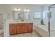 Bathroom featuring double vanity with framed mirrors and a soaking tub beneath a window at 240 Mayfield Dr, Goose Creek, SC 29445