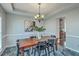 Elegant dining room with a large wooden table, six chairs, statement lighting, and decorative wall art at 240 Mayfield Dr, Goose Creek, SC 29445