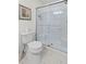 White tiled shower with glass doors and white toilet with storage rack at 241 Kelsey Blvd, Wando, SC 29492