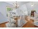 Bright dining area featuring modern chandelier, glass table, and natural lighting at 241 Kelsey Blvd, Wando, SC 29492