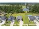 Aerial view of properties with green lawns, pool, and a serene pond on a sunny day at 255 Saxony Loop, Summerville, SC 29486