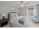 A well lit bedroom features a ceiling fan, a stylish chair, and plush bedding at 255 Saxony Loop, Summerville, SC 29486