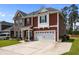 Attractive two-story house featuring brick, red siding, and a two-car garage on a sunny day at 255 Saxony Loop, Summerville, SC 29486