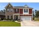 Inviting two-story home featuring brick and red siding, attached two-car garage, and manicured lawn at 255 Saxony Loop, Summerville, SC 29486