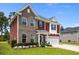 Charming two-story home with brick and red siding, a well-maintained lawn and landscaping at 255 Saxony Loop, Summerville, SC 29486