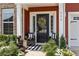 Cozy front porch featuring chairs, striped rug, potted plants, and a decorative wreath on the door at 255 Saxony Loop, Summerville, SC 29486