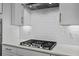 Modern kitchen with white cabinets, quartz countertops, subway tile backsplash, and stainless steel gas cooktop at 255 Saxony Loop, Summerville, SC 29486