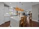 Open kitchen featuring island with chairs, quartz countertops, rattan pendant lights, and wood floors at 255 Saxony Loop, Summerville, SC 29486