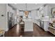 Modern kitchen with stainless steel appliances, white cabinetry, an island with seating, and hardwood floors at 255 Saxony Loop, Summerville, SC 29486