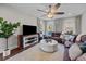 Spacious living room with large brown leather sofa, area rug, ceiling fan, and large windows at 255 Saxony Loop, Summerville, SC 29486