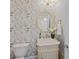 Elegant powder room with floral wallpaper, marble sink vanity, and a decorative mirror at 255 Saxony Loop, Summerville, SC 29486