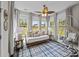 Cozy sunroom with daybed, decorative pillows, lamps, and large windows with outdoor views at 255 Saxony Loop, Summerville, SC 29486
