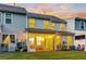 Backyard view featuring a screened-in porch with string lights and green grass at sunset at 2582 Kingsfield St, Mount Pleasant, SC 29466