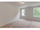 Empty bedroom featuring plush carpet, two windows offering lots of natural light, and base molding at 2582 Kingsfield St, Mount Pleasant, SC 29466