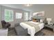 Well-lit bedroom featuring a bed, sitting area, and decorative mirror at 2582 Kingsfield St, Mount Pleasant, SC 29466