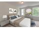 Bedroom with two windows, a queen bed, and artwork hung above the bed and on the wall at 2582 Kingsfield St, Mount Pleasant, SC 29466