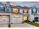 Exterior elevation featuring a row of townhomes with garages, driveways, and manicured lawns at dusk at 2582 Kingsfield St, Mount Pleasant, SC 29466