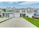 Exterior view of townhomes, featuring driveways, garages, landscaping, and unique color schemes at 2582 Kingsfield St, Mount Pleasant, SC 29466