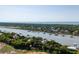 Scenic aerial shot showcases waterfront homes with private docks on a serene waterway with ocean backdrop at 2619 Buccaneer Rd, Isle of Palms, SC 29451