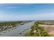 Expansive aerial view of waterfront homes with private docks, complemented by lush greenery and a distant bridge at 2619 Buccaneer Rd, Isle of Palms, SC 29451